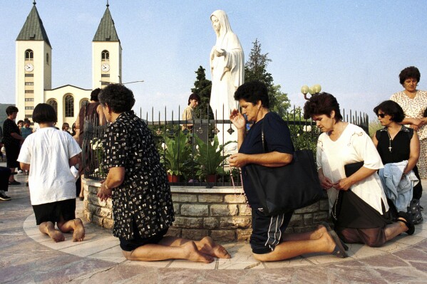 Bosnian Roman Catholic women pray on the occasion of the feast of the Assumption in Medjugorje, some 120 kilometers (75 miles) south of the Bosnian capital Sarajevo on Tuesday, August 15, 2000. Some 19 years ago six young people claimed Holy Mary appeared to them in the town of Medjugorje. On Friday, May 17, 2024, the Vatican will issue revised norms for discerning apparitions "and other supernatural phenomena," updating a set of guidelines first issued in 1978. (Ǻ Photo/Hidajet Delic, File)