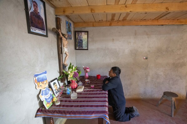 Marco Antulio Pablo Pérez ora en un altar por su hijo Anderson Pablo, quien murió tratando de migrar a Estados Unidos en Comitancillo, Guatemala, el miércoles 20 de marzo de 2024. El joven de 16 años murió entre los migrantes que fueron baleados e incendiados por Policías deshonestos en Camargo, México, en enero de 2021. (Foto AP/Moises Castillo)
