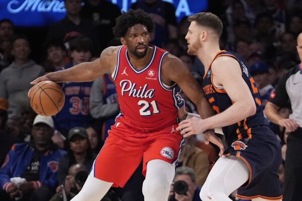 New York Knicks' Isaiah Hartenstein, right, defends against Philadelphia 76ers' Joel Embiid (21) during the second half of Game 2 in an NBA basketball first-round playoff series Monday, April 22, 2024, in New York. (AP Photo/Frank Franklin II)