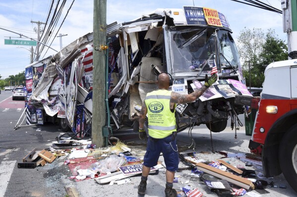 The remains of a bus owned by a couple that sold pro-Donald Trump merchandise is towed, Sunday, June 2, 2024, in the Staten Island borough of New York, after it crashed into several street signs and utility poles. Donna Eiden, who had been living in the bus with her husband, Rocky Granata, and their cat, said that she was sleeping inside the parked vehicle when when it began to roll crashing into signs and poles in its path. (Steve White/Staten Island Advance via AP)