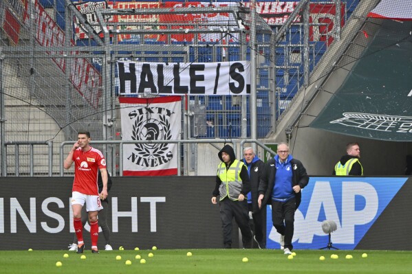 Tennis balls lie on the pitch after fans threw them to protest against the German Soccer Federation, during the German Bundesliga soccer match between TSG 1899 Hoffenheim and 1. FC Union Berlin at the PreZero Arena in Sinsheim, Germany, Saturday, Feb. 17, 2024. (Jan-Philipp Strobel/dpa via AP)