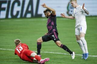 Iceland midfielder Hordur Ingi Gunnarsson (3) looks on as goalkeeper Runar Alex Runarsson (13) stops a shot by Mexico forward Henry Martin (9) during the second half of an international friendly soccer match, Saturday, May 29, 2021, in Arlington, Texas. (AP Photo/Brandon Wade)