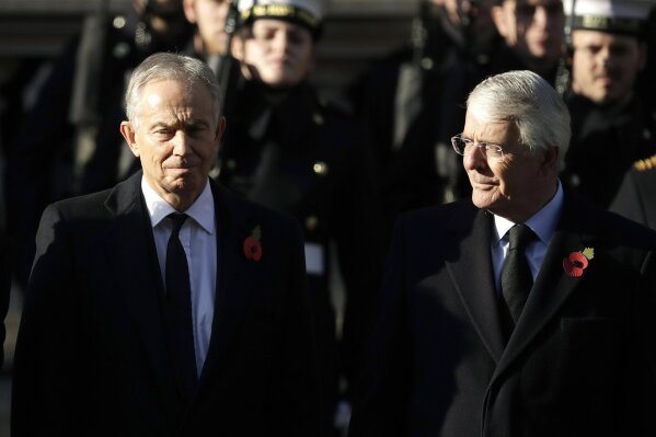 FILE - In this Sunday, Nov. 10, 2019 file photo, former British Prime Ministers Tony Blair, left and John Major attend the Remembrance Sunday ceremony at the Cenotaph in Whitehall in London. Remembrance Sunday is held each year to commemorate the service men and women who fought in past military conflicts. The two former British prime ministers who played crucial roles in bringing peace to Northern Ireland joined forces Sunday, Sept. 13, 2020 to urge lawmakers to reject government plans to over-ride the Brexit deal with the European Union, arguing that it imperils that peace as well as damaging the U.K.’s reputation.  (AP Photo/Matt Dunham, File)