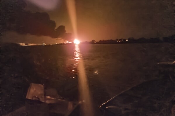 A fireball lights the horizon on the Ukrainian shore of the Danube, seen from Chilia Veche in eastern Romania on the night of Tuesday, Sept. 5, 2023. The discovery of drone debris on Romanian territory this week has left some local residents fearing that the war in neighboring Ukraine could spread into their country, as Russian forces bombard Ukrainian ports just across the Danube River from NATO-member Romania. (Mircea Franc via AP)