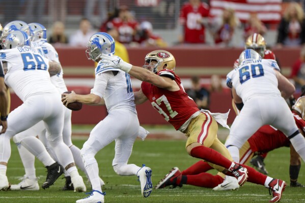 San Francisco 49ers' defensive end Nick Bosa, center right, gets the second of two sacks against Detroit Lions' quarterback Jared Goff, center left, in the second quarter of the NFC Championship NFL football game in Santa Clara, Calif., Sunday, Jan. 28, 2024. (Carlos Avila Gonzalez/San Francisco Chronicle via AP)