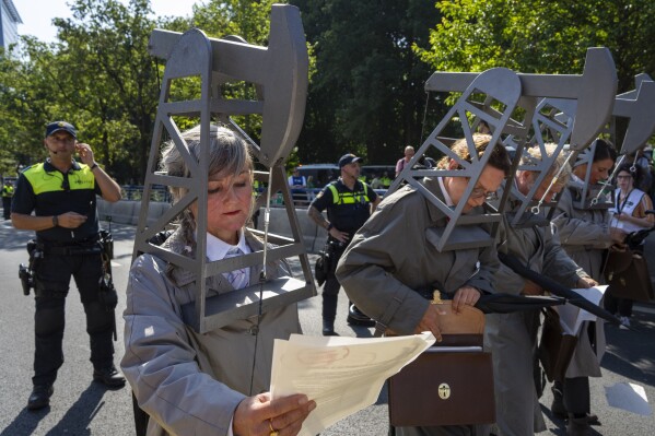 Protestors dressed as pumpjacks blocked a highway during a climate protest of Extinction Rebellion and other activists near the Dutch parliament in The Hague, Netherlands, Saturday, Sept. 9, 2023. (AP Photo/Peter Dejong)