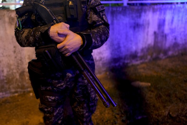 A police officer stands guard on a street in Rosario, Argentina, Monday, April 8, 2024. President Javier Milei has promised to prosecute gang members as terrorists and change the law to allow the army into crime-ridden streets for the first time since Argentina's brutal military dictatorship ended in 1983. (AP Photo/Natacha Pisarenko)