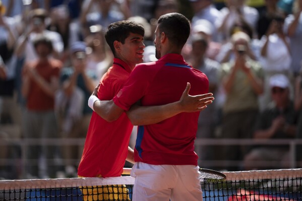 Serbia's Novak Djokovic and Spain's Carlos Alcaraz great each other after the men's singles tennis final at the Roland Garros stadium during the 2024 Summer Olympics, Sunday, Aug. 4, 2024, in Paris, France. (AP Photo/Louise Delmotte)