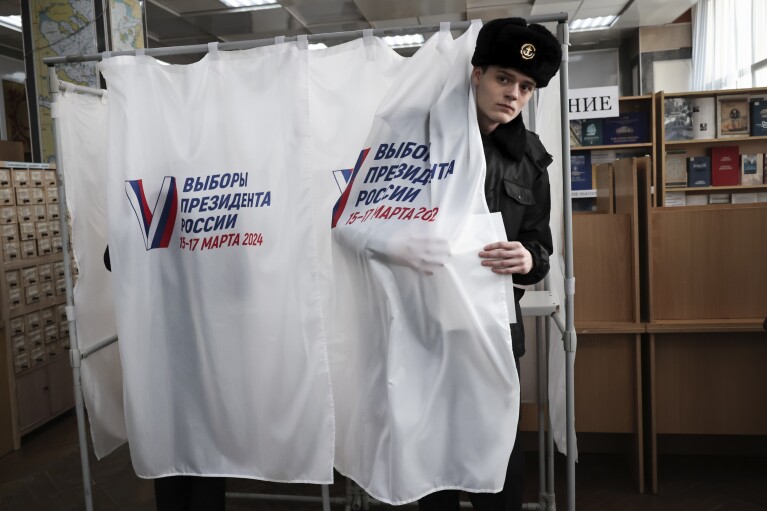 Un estudiante de la Universidad Marítima Estatal que lleva el nombre del almirante Gennady Nevelskoy abandona la cabina de votación en un colegio electoral durante las elecciones presidenciales en la ciudad portuaria de Vladivostok, en el Pacífico, a 6.418 kilómetros de distancia.  (3.566 millas) al este de Moscú, Rusia, viernes 15 de marzo de 2024. Los votantes en Rusia se dirigen a las urnas para una elección presidencial que seguramente extenderá el gobierno del presidente Vladimir Putin después de que reprimió la disidencia.  (foto AP)