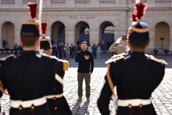 Ukrainian President Volodymyr Zelensky listens to the Ukrainian national anthem at the Les Invalides memorial during a military honors ceremony in Paris, Friday, June 7, 2024. (Samir Al-Doumi via The Associated Press)