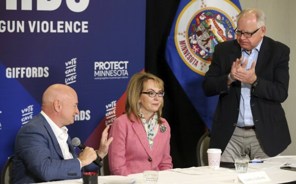 
              In this Oct. 26, 2018 photo, Minnesota gubernatorial candidate, Democrat Tim Walz, right, applauds as Capt. Mark Kelly, left, introduces his wife, former Rep. Gabby Giffords as they hosted a roundtable against gun violence in Minneapolis. The 2018 election marks the first time that groups supporting gun control measures could spend more on a campaign than the National Rifle Association.  (AP Photo/Jim Mone)
            