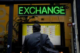 FILE - A man checks rates at a money exchange house in Buenos Aires, Argentina, July 14, 2022. The government implemented a new regulation on Nov. 4, 2022 allowing visitors using credit and debit cards to obtain a more favorable exchange rate through financial markets that will give them far more pesos than the official rate. (AP Photo/Natacha Pisarenko, File)