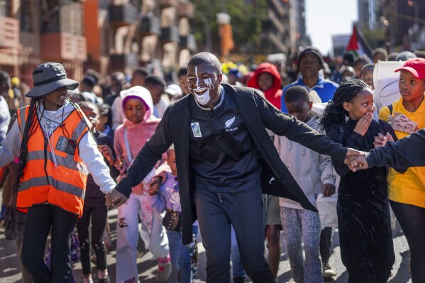 People participate in the annual Hillbrow street parade organized by the Windybrow Arts Centre and other local organisations in downtown Johannesburg, South Africa, Saturday, May 24, 2025. (AP Photo/Jerome Delay)