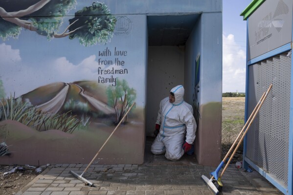 FILE - Volunteers from the ZAKA rescue service remove blood stains from a public bomb shelter on a road near the Israeli-Gaza border in the aftermath of the Oct. 7 Hamas attack, Nov. 20, 2023. Some allege the accounts of sexual assault were purposely concocted. Zaka officials and others dispute that. Regardless, AP’s examination of Zaka’s handling of the now debunked stories shows how information can be clouded and distorted in the chaos of the conflict. (AP Photo/Ohad Zwigenberg, File)