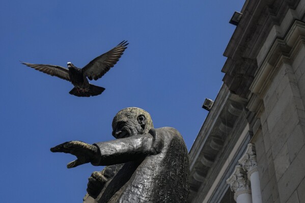 A pigeon flies over a statue Chilean Cardinal Raúl Silva Henríquez located outside the Cathedral in the Plaza de Armas in Santiago, Chile, Thursday, Aug. 31, 2023. Silva Henríquez founded the human rights organization Vicariate of Solidarity that was led by social workers, lawyers, archivists and physicians, to provide support to those harmed by the Augusto Pinochet regime. (AP Photo/Esteban Felix)