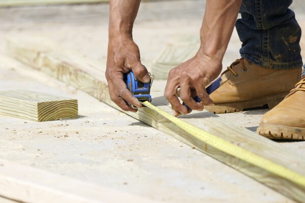 A beam is measured and marked at a housing site in Madison County, Miss., Tuesday, March 16, 2021. (AP Photo/Rogelio V. Solis, File)
