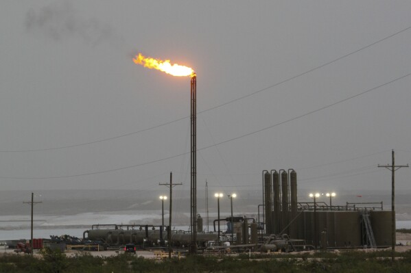 Strong winds kick up dust as a facility in the Permian Basin flares natural gas east of Carlsbad, N.M., on Monday, May 19, 2025. (AP Photo/Susan Montoya Bryan)