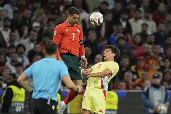 Portugal's Cristiano Ronaldo, top, heads the ball next to Spain's Robin Le Normand during the Nations League final soccer match between Portugal and Spain at the Allianz Arena in Munich, Germany, Sunday, June 8, 2025. (AP Photo/Martin Meissner)