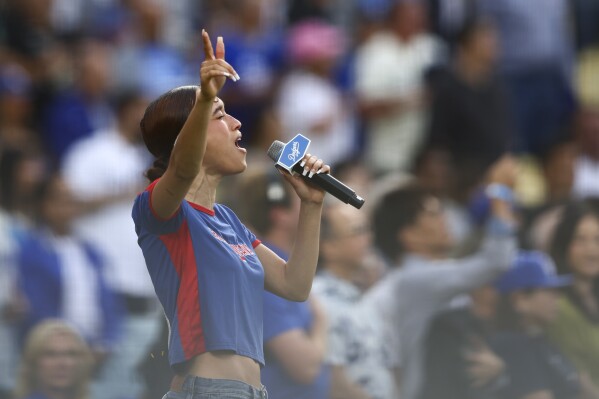 Music artist Nezza sings the national anthem prior to a baseball game between the Los Angeles Dodgers and the San Francisco Giants in Los Angeles, Saturday, June 14, 2025. (AP Photo/Jessie Alcheh, File)