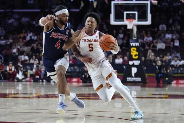 Southern California guard Boogie Ellis (5) is defended by Arizona guard Kylan Boswell (4) during the first half of an NCAA college basketball game Saturday, March 9, 2024, in Los Angeles. (AP Photo/Marcio Jose Sanchez)