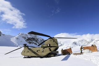 FILE - Soldiers and National Park Service personnel offload equipment and supplies from a U.S. Army CH-47 Chinook helicopter on Kahiltna Glacier on April 27, 2022. The Army says it has grounded its fleet of Chinook cargo helicopters after fuel leaks caused a "small number" of engine fires. (John Pennell/U.S. Army via AP, File)