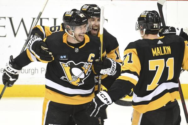 Pittsburgh Penguins center Sidney Crosby (87) celebrates his overtime goal against the Columbus Blue Jackets with left wing Jason Zucker (16) and center Evgeni Malkin (71) during an NHL hockey game, Tuesday, March 7, 2023, in Pittsburgh. The Penguins won 5-4. (AP Photo/Philip G. Pavely)