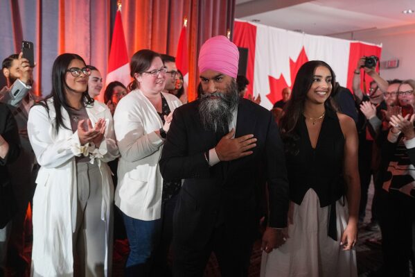 NDP Leader Jagmeet Singh, center, walks with his wife Gurkiran Kaur as he arrives to address supporters on election night, in Burnaby, B.C., on Monday, April 28, 2025. (Darryl Dyck/The Canadian Press via AP)