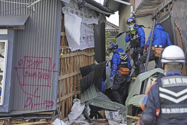 Rescuers conduct a search operation in Suzu, Ishikawa prefecture, Japan Friday, Jan. 5, 2024. Monday’s temblor decimated houses, twisted and scarred roads and scattered boats like toys in the waters, and prompted tsunami warnings. (Kyodo News via AP)