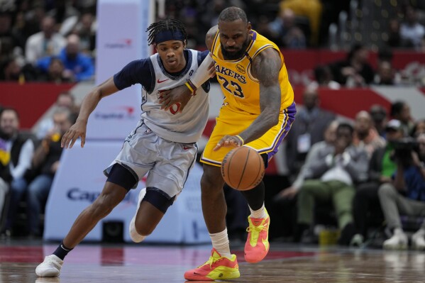 Washington Wizards guard Bilal Coulibaly (0) defends as Los Angeles Lakers forward LeBron James (23) recovers the ball during the first half of an NBA basketball game Thursday, Jan. 30, 2025, in Washington. (AP Photo/Jess Rapfogel)