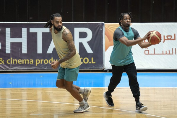 Isaac Banks, left, and, Uchenna Iroegbu, right, American basketball players with the Hashed al-Shaabi - the Popular Mobilization Forces - in the Iraqi Basketball Super League, take part in a team practice in Baghdad, Iraq, Thursday, March 21, 2024. U.S. players are in high demand on Iraqi basketball teams, even those whose owners have a tense relationship with Washington. (AP Photo/Hadi Mizban)