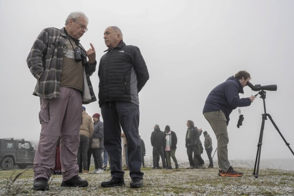 yossi leshem, professor emeritus at tel aviv university's school of zoology, left, and retired gen. mansour abu rashid, former director of jordanian military intelligence, chat as a birdwatcher look on through his monocular while fog covers the karla lake, near the town of stefanovikeio, larissa, central greece, on jan. 22, 2025. (ap photo/petros giannakouris)
