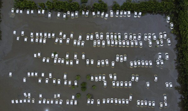 A private car warehouse is submerged in water from River Hindon following excessive rains, in Greater Noida, out skirts of New Delhi, India, Wednesday, July 26, 2023. (AP Photo/Piyush Nagpal)