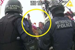 This image from Washington Metropolitan Police Department body-worn video, released and annotated by the Justice Department in the statement of facts supporting an arrest warrant for Jay James Johnston, shows Johnston, circled in yellow, at the U.S. Capitol on Jan. 6, 2021, in Washington. Johnston, the actor known for his roles on the comedy television shows "Bob's Burgers" and "Mr. Show with Bob and David" has been arrested on charges that he joined a mob of Donald Trump supporters in confronting police officers during the U.S. Capitol riot. (Justice Department via AP)