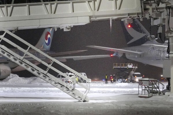A Korean Air plane, left, and Cathay Pacific aircraft, right, are seen after a collision at northern Japan's New Chitose Airport in Sapporo, Tuesday, Jan. 16, 2024. A Korean Air plane carrying 289 people hit a parked Cathay Pacific aircraft while being pushed by a ground vehicle ahead of takeoff at northern Japan's New Chitose Airport on Tuesday but caused no fire or injuries, fire and airline officials said. (Kyodo News via AP)