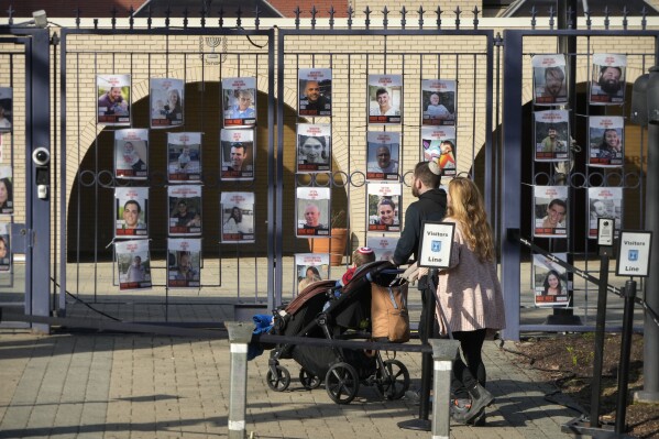 A family walks up to the entrance of the Israeli Embassy, Monday, Feb. 26, 2024, in Washington. An active-duty member of the U.S. Air Force has died after he set himself ablaze outside the Israeli Embassy in Washington, D.C., while declaring that he 