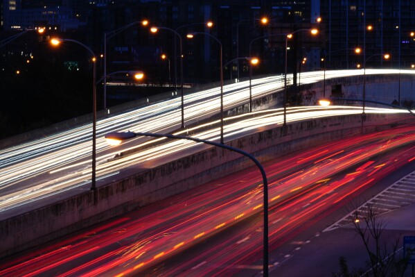 File - In this image made with a long exposure, motorists move along Interstate 76 ahead of the Thanksgiving Day holiday in Philadelphia, Nov. 22, 2023. U.S. inflation ticked down again last month, with cheaper gas helping further lighten the weight of consumer price increases in the United States. (AP Photo/Matt Rourke, File)