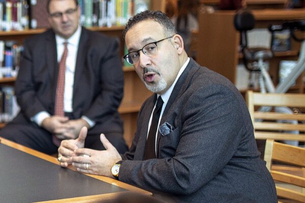 FILE - In this Jan. 28, 2020 file photo, Connecticut State Commissioner of Education Miguel Cardona speaks with Berlin High School students while on a tour of the school. President-elect Joe Biden has chosen the education commissioner for Connecticut and a former public school teacher to serve as education secretary.  (Devin Leith-Yessian/Berlin Citizen/Record-Journal via AP)