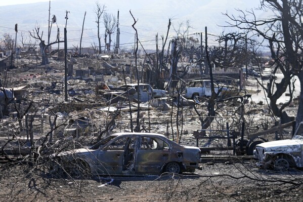 Destroyed homes and cars are shown, Sunday, Aug. 13, 2023, in Lahaina, Hawaii. Hawaii officials urge tourists to avoid traveling to Maui as many hotels prepare to house evacuees and first responders on the island where a wildfire demolished a historic town and killed dozens. (AP Photo/Rick Bowmer)