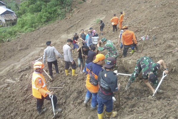 In this photo released by the Indonesian National Search and Rescue Agency (BASARNAS), rescuers search for survivors at a village hit by a landslide in Tana Toraja district of South Sulawesi province, Indonesia, Monday, April 15, 2024. A search and rescue team found multiple people killed by landslides on Indonesia's Sulawesi island and are still looking for a few missing, officials said Monday. (National Search and Rescue Agency via AP)
