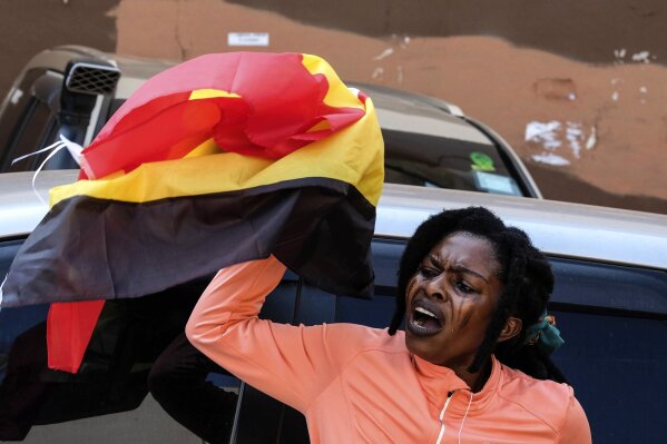 A protester holding a her country national flag during the anticorruption protest in Kampala, Uganda, Tuesday, July 23, 2024. Ugandan security forces on Tuesday arrested dozens of people who tried to walk to the parliament building to demonstrate against high-level corruption in protests that authorities say are unlawful. (ĢӰԺ Photo/Hajarah Nalwadda)