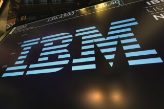 FILE - In this March 18, 2019, file photo, the logo for IBM appears above a trading post on the floor of the New York Stock Exchange.  IBM says it is breaking off a $19 billion chunk of its business to focus on cloud computing. The 109-year-old tech company said Thursday, Oct. 8, 2020,  it is spinning off its managed infrastructure services unit into a new public company, temporarily named NewCo.  (AP Photo/Richard Drew, File)