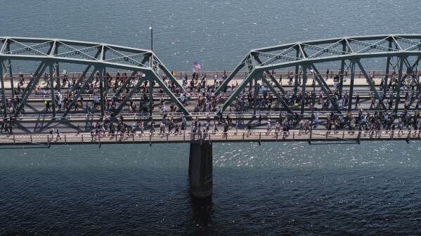Demonstrators cross the Hawthorne Bridge as they take part in the "No Kings" protest, Saturday, June 14, 2025, in Portland, Ore. (AP Photo/Jenny Kane)