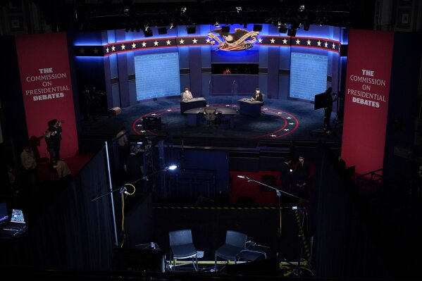 Members of the production crew stand in on the stage near plexiglass barriers which will serve as a way to protect the spread of COVID-19 as preparations take place for the vice presidential debate at the University of Utah, Tuesday, Oct. 6, 2020, in Salt Lake City. The vice presidential debate between Vice President Mike Pence and Democratic vice presidential candidate Sen. Kamala Harris, D-Calif., is scheduled for Oct. 7.  (AP Photo/Julio Cortez)