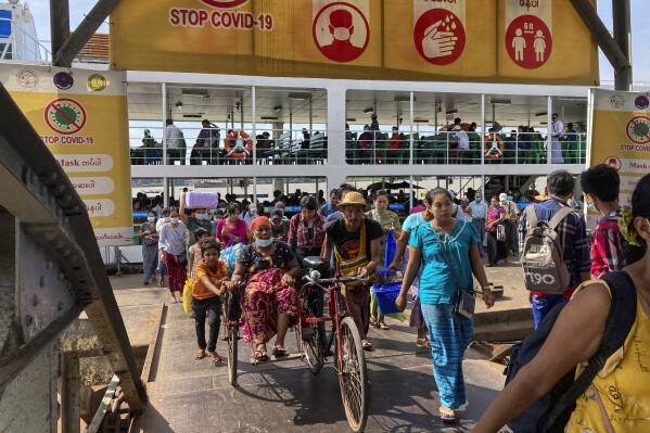 FILE - People disembark from a ferry at the Pansodan jetty in Yangon, Myanmar on Nov. 12, 2021. Myanmar, once a thriving emerging economy, is struggling to regain momentum as the country’s civil war increasingly disrupts trade and livelihoods. World Bank economists estimate the country's economy grew at a 1% annual pace in the year that ended in March, more slowly than earlier expected, according to a report issued Wednesday, June 12, 2024.(AP Photo/File)