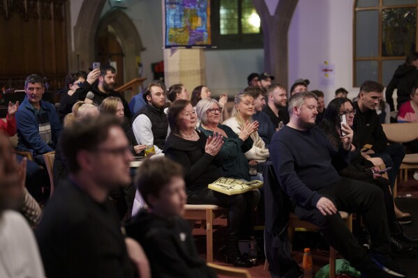 Los espectadores aplauden durante un espectáculo de Kingdom Wrestling en la iglesia de San Pedro en Shipley, el sábado 29 de marzo de 2025. (Foto AP/Jon Super)