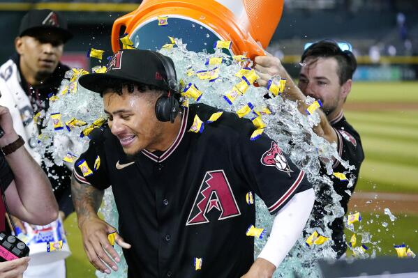 Arizona Diamondbacks' Sergio Alcantara gets showered with liquid and bubble gum by Cooper Hummel, right, after his game-ending, three-run home run in the 10th inning against the Los Angeles Dodgers in a baseball game in Phoenix, Wednesday, Sept. 14, 2022. The Diamondbacks won 5-3. (AP Photo/Ross D. Franklin)