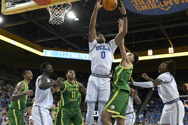 UCLA guard Jaylen Clark (0) and Oregon guard Will Richardson battle for a rebound during the first half of an NCAA college basketball game Sunday, Dec. 4, 2022, in Los Angeles. (AP Photo/John McCoy)