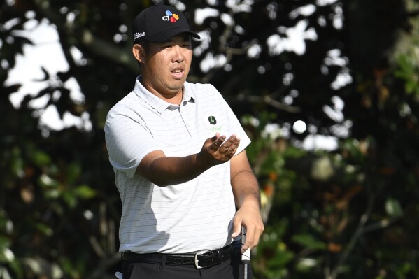 Byeong Hun An, of South Korea, tosses his ball to his caddie on the first green during the second round of the Arnold Palmer Invitational golf tournament, Friday, March 8, 2024, in Orlando, Fla. (AP Photo/Phelan M. Ebenhack)