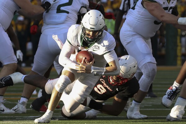 Houston defensive lineman Nelson Ceaser (9) sacks Baylor Bears quarterback Blake Shapen, center, during the second half of an NCAA college football game, Saturday, Nov. 4, 2023, in Waco, Texas. (Jerry Larson/Waco Tribune-Herald via AP)