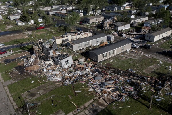 Storm-damaged mobile homes are surrounded by debris at the Pavilion Estates mobile home park just east of Kalamazoo, Michigan, Wednesday, May 8, 2024. A tornado ripped through the area on the evening of May 7.  (Neil Blake/The Grand Rapids Press via AP)